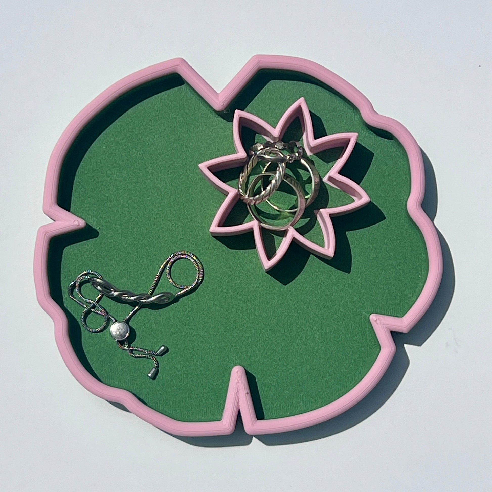 Matcha green lily pad trinket tray holding silver jewellery with a matching lily flower dish