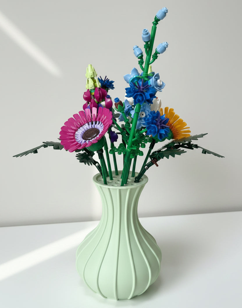 Colourful bouquet of flowers in a light green vase. 