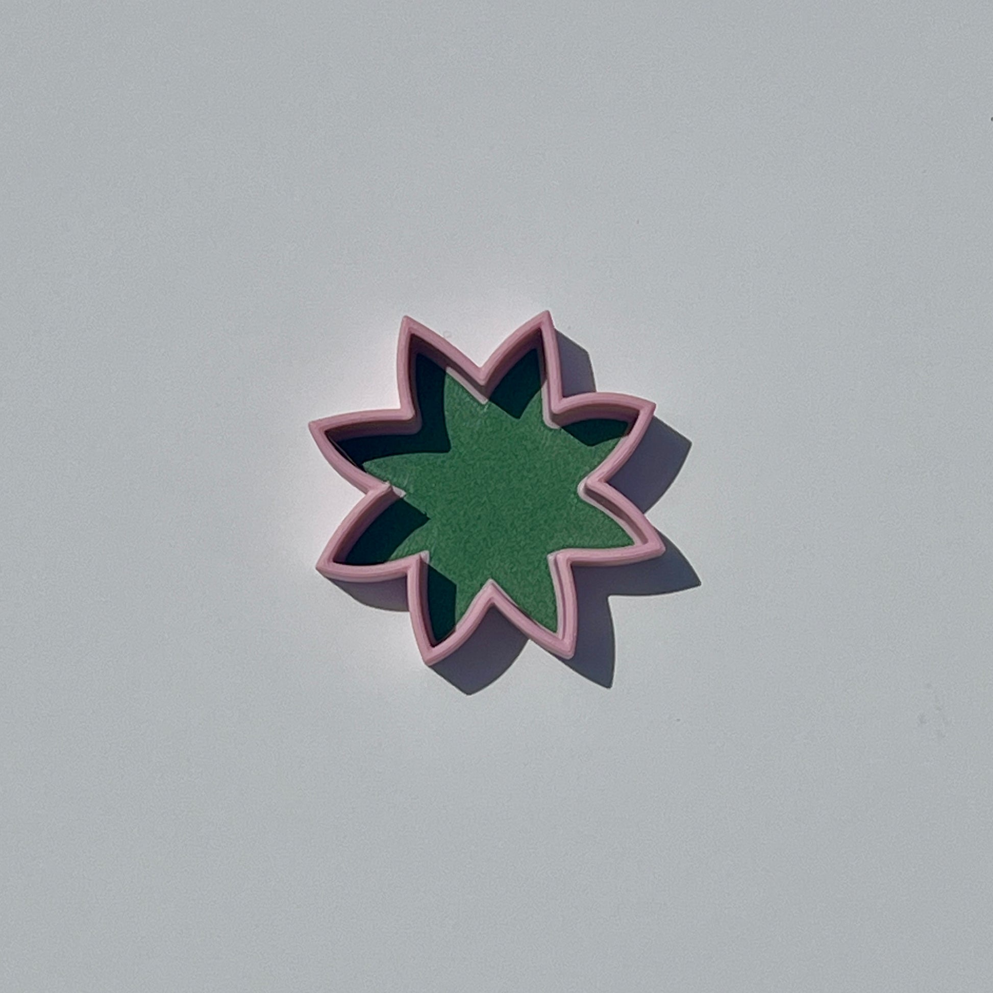 Small lily flower-shaped trinket dish in matcha green with sakura pink edging.
