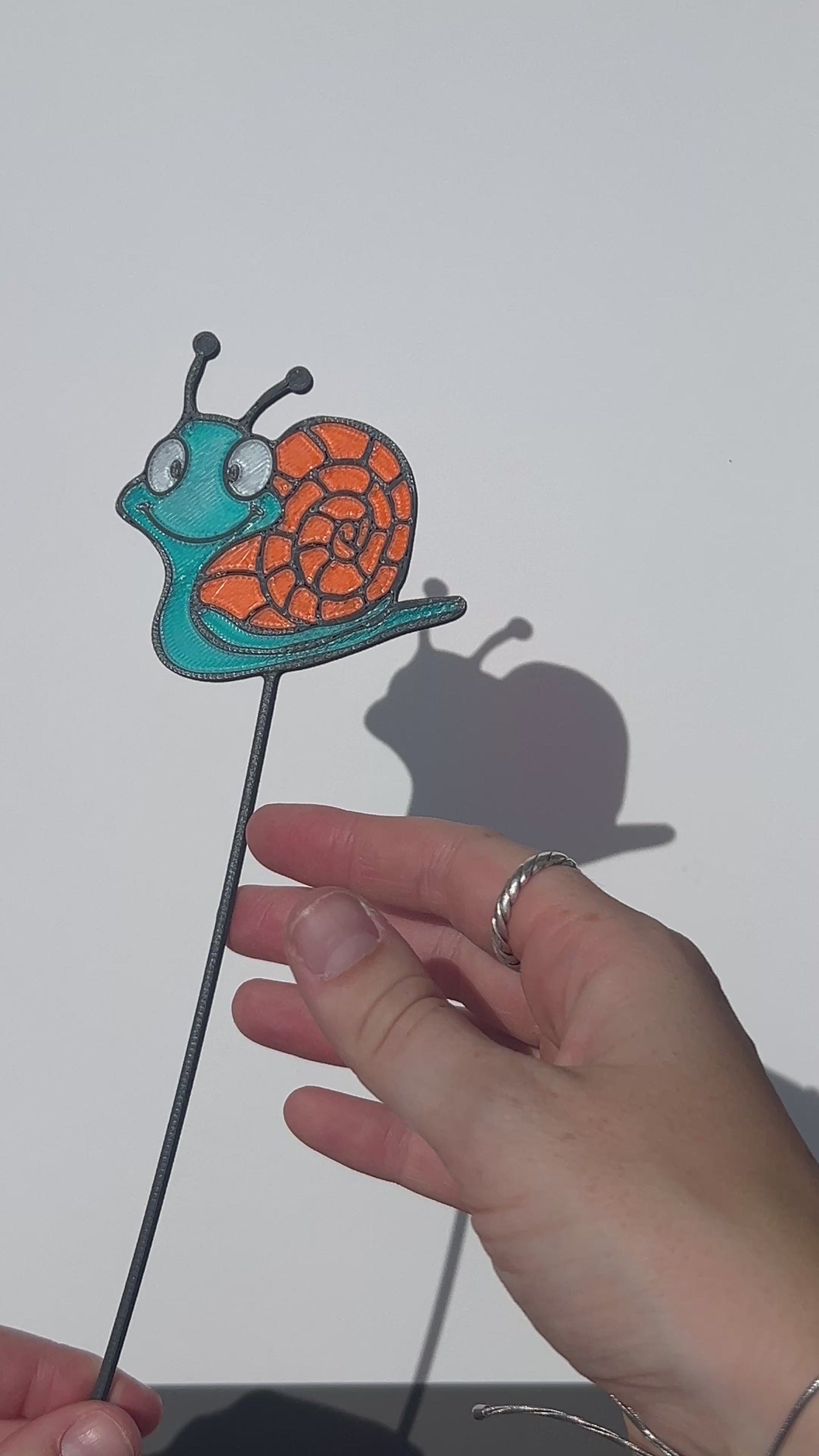 Turquoise and orange translucent PLA snail decorative stem with a stained-glass-inspired design.
